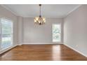 Dining room with wood floors, chandelier, neutral colors, and natural light from two windows at 1665 Little Lisa Ln, Snellville, GA 30078