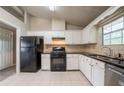 Bright kitchen featuring white cabinets, black appliances, and granite countertops at 2132 Sara Ashley Way, Lithonia, GA 30058