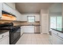 Well-lit kitchen featuring white cabinets, stainless steel appliances, and tile flooring at 2132 Sara Ashley Way, Lithonia, GA 30058
