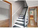 Elegant staircase with wooden rails and contrasting black and white steps, adding visual interest at 620 Shannon Green Sw Cir, Mableton, GA 30126