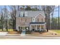 Beautiful two-story brick home with a covered porch and well-manicured front yard in a suburban setting at 219 Whispering Pines Ave, Conyers, GA 30094