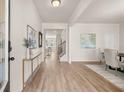 Bright foyer with hardwood floors, console table, and artwork leading to the dining area and staircase at 219 Whispering Pines Ave, Conyers, GA 30094
