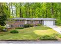 Charming single-story brick home with a well-manicured lawn and blue shutters at 2558 Landeau Cir, Tucker, GA 30084