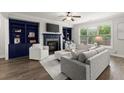 Cozy living room with built-in bookshelves, a fireplace, and a large window at 7340 Jamestown Dr, Alpharetta, GA 30005