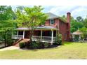 Charming two-story brick home featuring a welcoming front porch and lush landscaping at 2230 Cammie Wages Rd, Dacula, GA 30019