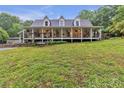 Charming home featuring a sprawling front porch with hanging plants, greenery and a swing at 143 Navajo Trl, Rydal, GA 30171