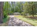 Long driveway leading to a charming one-story home surrounded by lush trees at 1992 Cascade Sw Rd, Atlanta, GA 30311