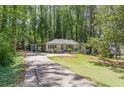Long driveway leading to a charming one-story home surrounded by lush trees at 1992 Cascade Sw Rd, Atlanta, GA 30311