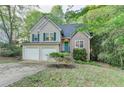 Charming two-story home with a two-car garage and well-maintained front yard, complemented by lush greenery at 1635 Rushing River Way, Suwanee, GA 30024