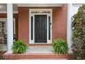 Charming front door entrance with brick facade, columns and lush greenery, creating a welcoming curb appeal at 1692 Holcomb Lake Rd, Marietta, GA 30062