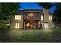 A view of the back of the home highlighting its screened porch, wooden stairs, and a spacious backyard at 2978 Legislative Ln, Buford, GA 30519
