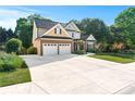 Two-story house featuring a large driveway, a two-car garage and mature trees at 2978 Legislative Ln, Buford, GA 30519
