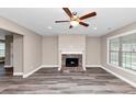 Bright living room featuring a stone fireplace, modern ceiling fan, and stylish wood-look flooring at 6755 Biscayne Blvd, Rex, GA 30273