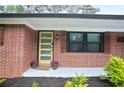 Close up of the front door entryway; the vibrant yellow door is framed by stylish shutters and fresh landscaping at 2738 Westchester Dr, Atlanta, GA 30344