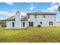 Back exterior of a light blue two-story house with a chimney, windows, and glass sliding door at 4129 Flakes Mill Manor Ln, Ellenwood, GA 30294