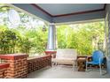 Inviting front porch features brick pillars, a birdhouse, bench seating, and pleasant green views at 959 Berne Se St, Atlanta, GA 30316
