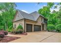 Spacious three-car garage with driveway, surrounded by mature trees and landscaped gardens at 106 Stephens Farm Dr, Canton, GA 30115