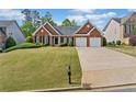 Beautiful one-story brick home with manicured lawn and a two-car garage at 1435 Harburn Ct, Cumming, GA 30041