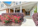 Inviting covered porch featuring classic columns, brick accents, and a stylish entrance with complementary blue shutters at 2055 Hickory Station Cir, Snellville, GA 30078
