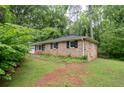 Brick home with an attached garage and lush lawn showcases classic suburban charm at 980 Oakton Sw Dr, Marietta, GA 30060