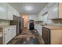 Well-lit kitchen features stainless steel appliances, stone tile flooring, and white cabinetry at 228 Amour Sw Way, Lilburn, GA 30047