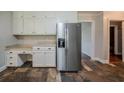 Spacious kitchen offers built-in desk area, stainless steel fridge and ample cabinet space at 228 Amour Sw Way, Lilburn, GA 30047