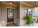 Inviting front porch with a decorative door, brick accents, and cozy seating area at 4876 Briarcliff Dr, Sugar Hill, GA 30518