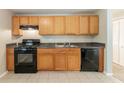 Functional kitchen featuring wood cabinets, a black gas range, and modern appliances at 1051 S Millard Way, Stone Mountain, GA 30088
