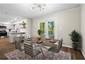 Dining room with seating for six, modern chandelier, and sliding glass doors to outside deck at 1911 Rollingwood Se Dr, Atlanta, GA 30316