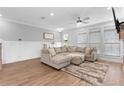 Living room with ample natural light, a cozy sectional, and hardwood floors at 300 Olmstead Way, Alpharetta, GA 30022
