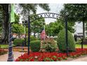 McDonough town square with an American flag surrounded by red flowers and lush greenery under a cloudy sky at 192 Weldon Rd, Mcdonough, GA 30253