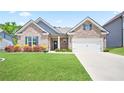 Lovely brick home featuring a well-maintained lawn and colorful flowerbeds at 3322 Grace Farm Ln, Buford, GA 30519