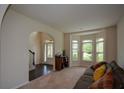 Bright living room features large bay windows, an arched doorway, and neutral decor, perfect for entertaining at 6816 Diamond Dr, Rex, GA 30273