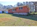 A charming one-story brick home with a well-maintained lawn, seen from an angle at 118 Ingleside Dr, Jonesboro, GA 30236