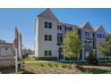 Beautiful townhome showing front lawn, manicured shrubs, and sign for East Park Village at 1899 Deco Dr, Kennesaw, GA 30144