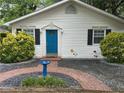 Inviting home exterior showcasing a vibrant blue front door, complemented by black shutters, bird bath, and a charming brick walkway at 1311 Sylvan Cir, Brookhaven, GA 30319