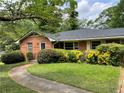 Charming single-story brick home features a walkway and lush landscaping at 2988 Ramble Ln, Decatur, GA 30033