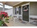 Inviting front porch featuring rocking chairs and decorative wreath, enhanced by a blooming rose bush at 59 Summer Nw Pl, Cartersville, GA 30121