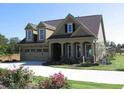 Traditional two-story home with a two-car garage, dormer windows and a beautifully landscaped lawn at 1213 Dawnview Dr, Locust Grove, GA 30248