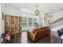 Open-concept living room with hardwood floors and large windows providing ample natural light at 215 Britten Pass, Alpharetta, GA 30009