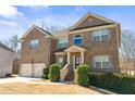 Charming brick home with a two-car garage, manicured shrubs, and a stylish front entrance at 4058 Rosebay Way, Conyers, GA 30094