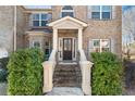 Inviting front entrance with decorative columns, lush greenery, and a stylish front door at 4058 Rosebay Way, Conyers, GA 30094