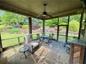 Cozy screened porch with stone flooring, comfortable seating, and views of the lush backyard at 5403 Timber Wild Ln, Buford, GA 30518