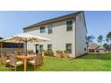 Spacious backyard featuring a patio set under a large umbrella on a well-manicured lawn at 89 Citadel Dr, Hampton, GA 30228