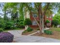 Brick home featuring a long driveway with mature trees and a well-maintained lawn at 1720 Greystone Trce, Conyers, GA 30013