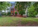 Brick home featuring a long driveway with mature trees and a well-maintained lawn at 1720 Greystone Trce, Conyers, GA 30013