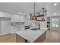 Modern kitchen with white cabinets, sleek countertops, designer backsplash, stainless steel appliances, and large island at 4336 Southvale Dr, Decatur, GA 30034