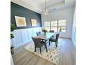 Cozy dining room featuring modern lighting, wainscotting, designer paint, and large window views at 261 Arborview Dr, Mcdonough, GA 30252