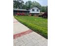 Well-manicured lawn and sidewalk leading up to a traditional home with mature landscaping and brick accents at 3996 Indian Manor Dr, Stone Mountain, GA 30083