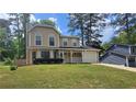 Inviting two-story home featuring an attached garage, well-maintained lawn, and classic architectural details at 5229 Mountain Village Ct, Stone Mountain, GA 30083